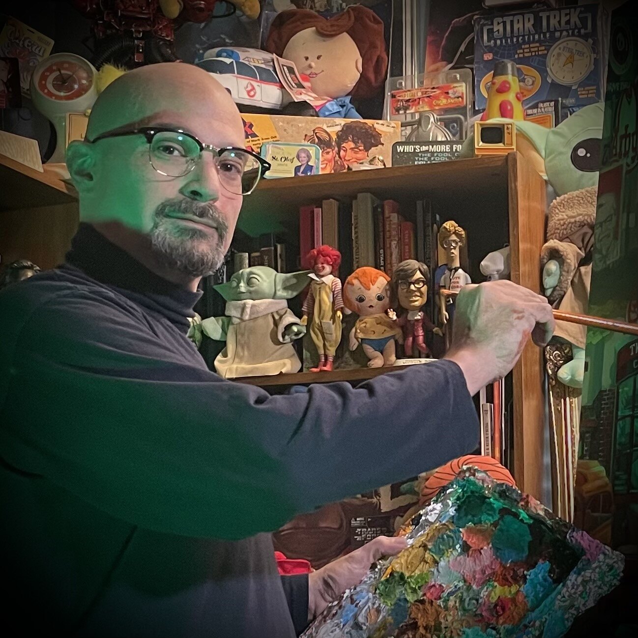 VicTorres painting in his studio, holding his paint palette